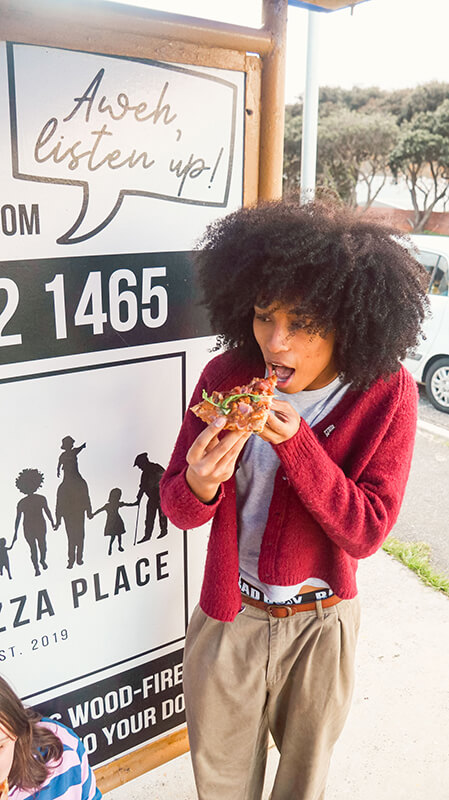 Teenager Enjoying Woodfired Pizza Slice